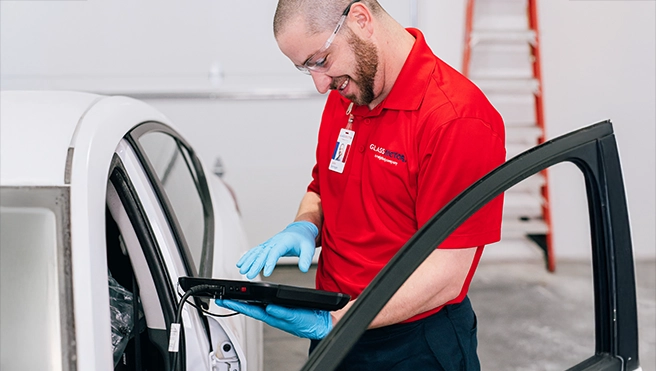 A Glass Doctor technician working on a customer's car.