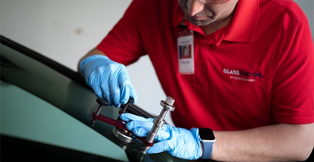 A Glass Doctor technician fixing a damaged car windshield.