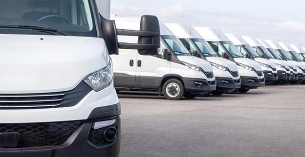  A picture of a white fleet of vans lined in a row.