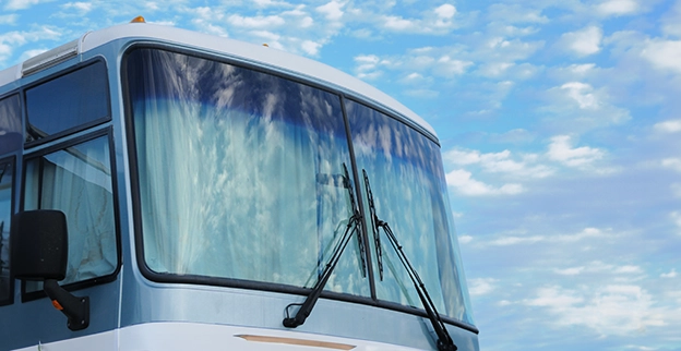 A picture of an RV parked in the sunshine.