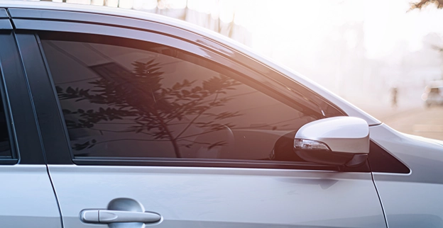 A picture of a silver sedan with tinted side windows.
