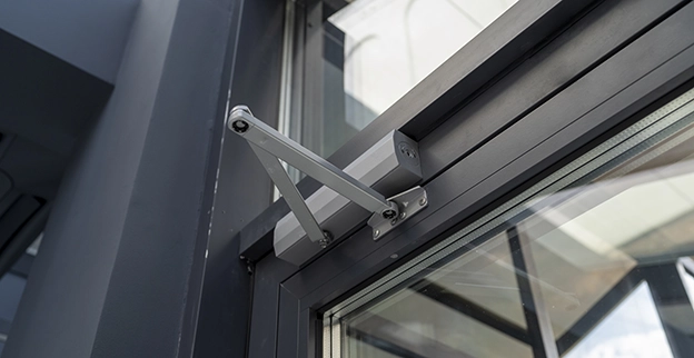 A closeup of a commercial door closer.