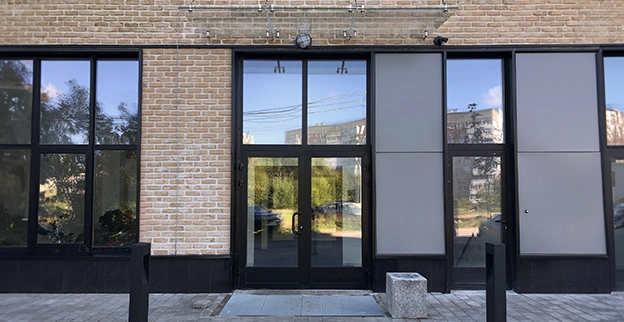 A picture of a ground level commercial storefront with glass doors.