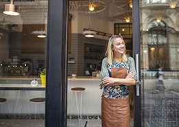 Woman standing outside of coffee shop. 