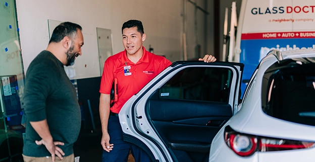 Glass Doctor professional holding open a car door.