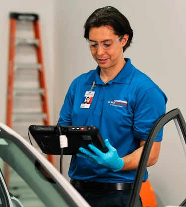 Glass Doctor professional inspecting car.