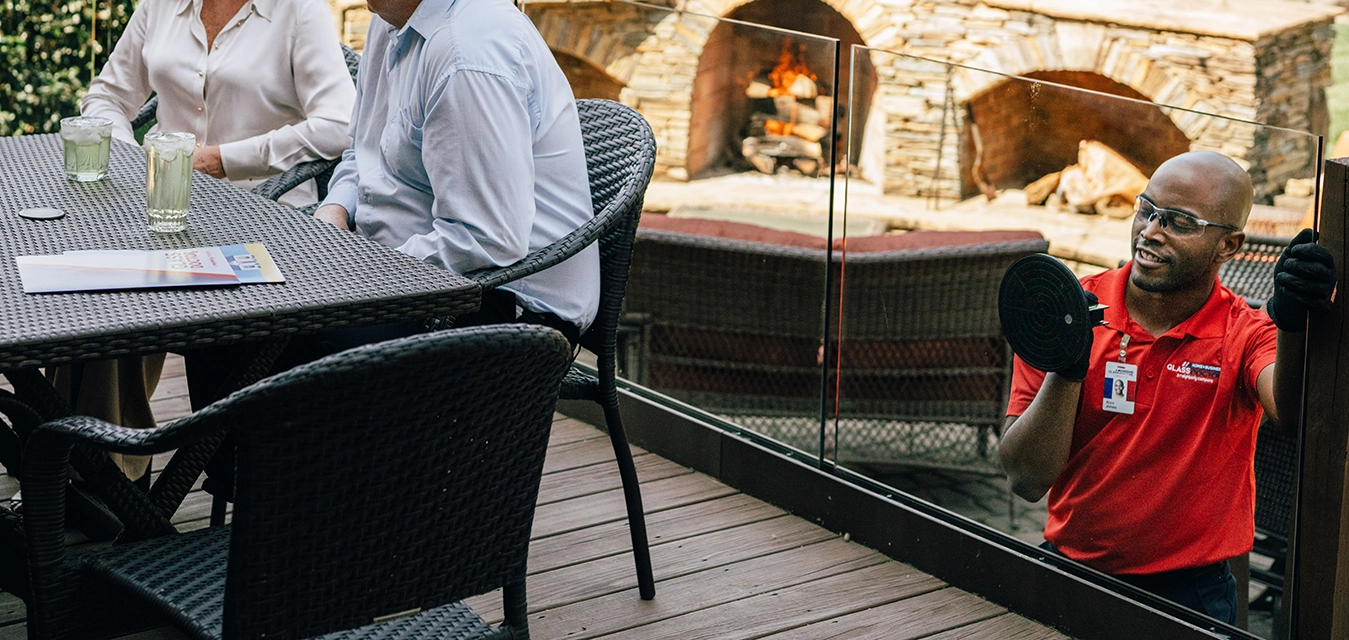 Technician holding glass in place with a suction device.