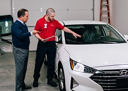 Glass Doctor professional showing car windshield to customer.