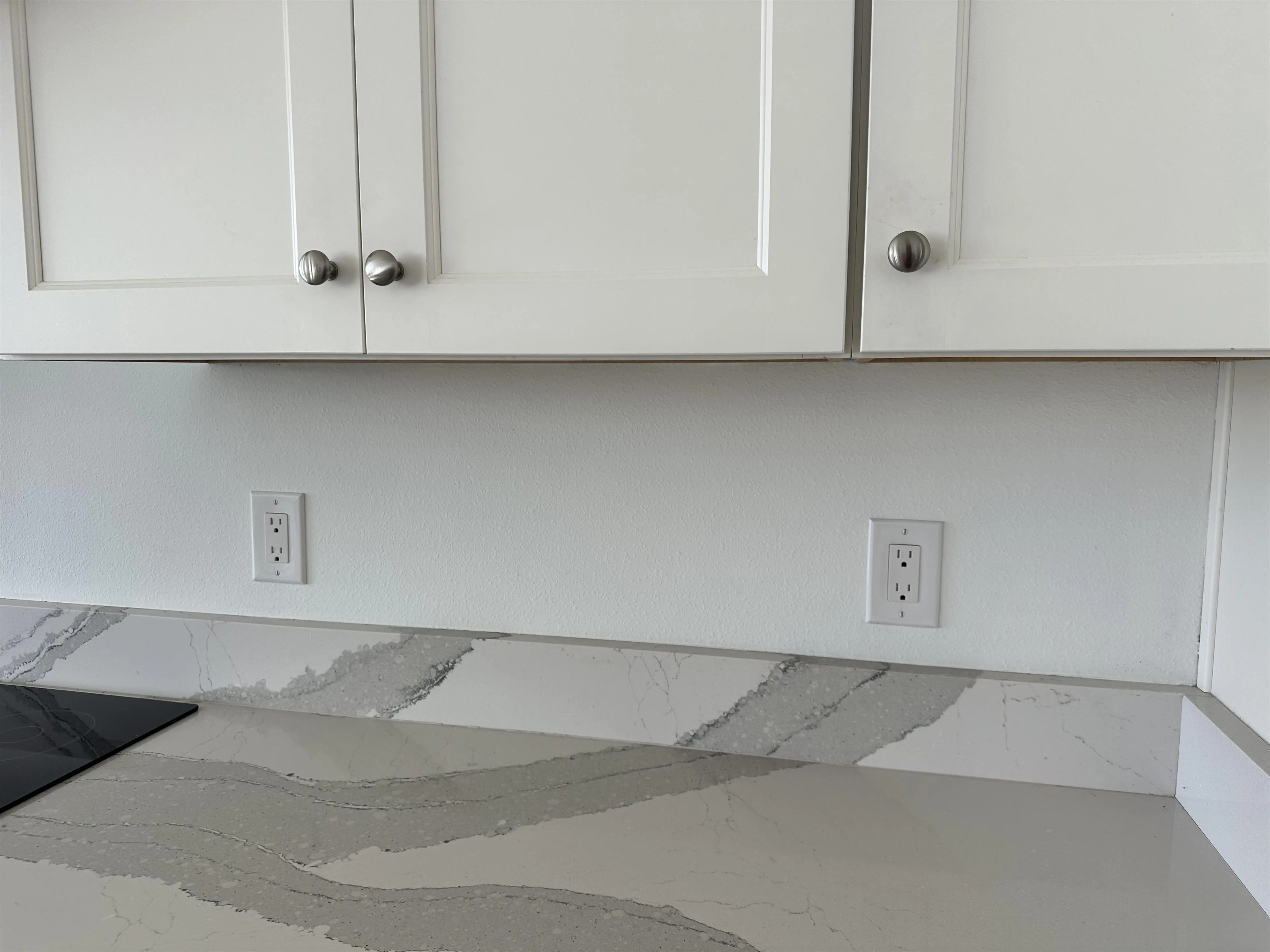 Plain white kitchen counter wall.