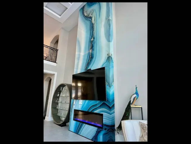 A custom fireplace wall with blue patterned IMAGIO glass design.