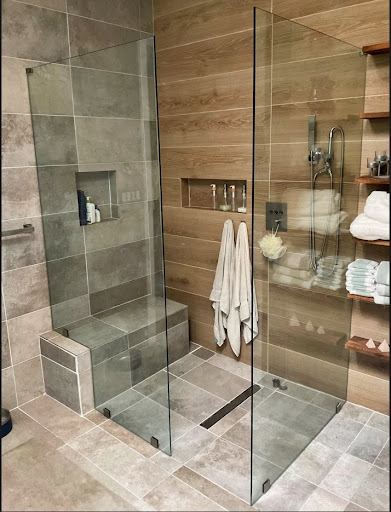 Frameless glass shower enclosure with minimal hardware with mixed tile.
