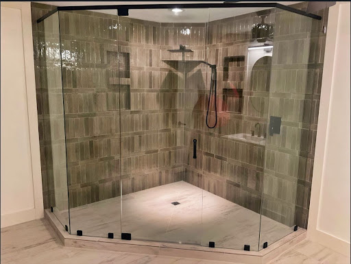 Neo-angle glass shower enclosure with black hardware.