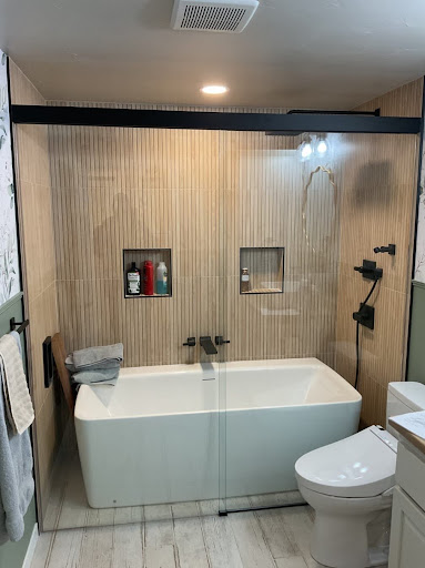 Semi-frameless sliding shower door and tub enclosure in a bathroom.