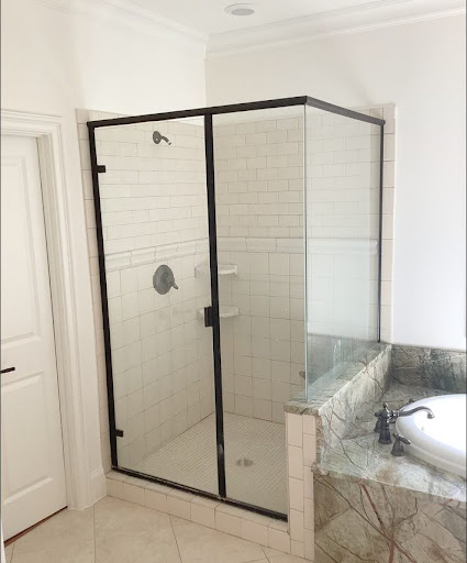 Hinged glass semi-frameless swing shower door in bathroom with subway tile.