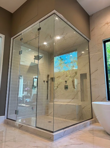 Steam shower glass enclosure with marble tile.