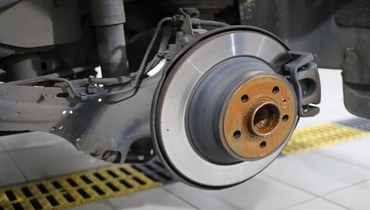 Closeup of a car with the wheel off exposing the brake system on the vehicle
