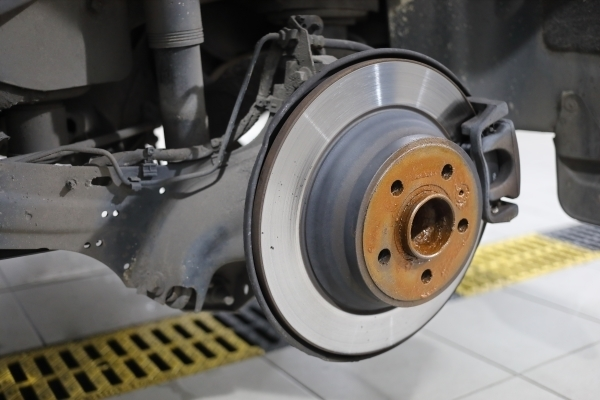 Closeup of a car with the wheel off exposing the brake system on the vehicle